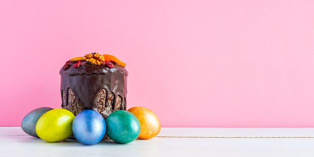 Torta di Pasqua e uova colorate sul rosa