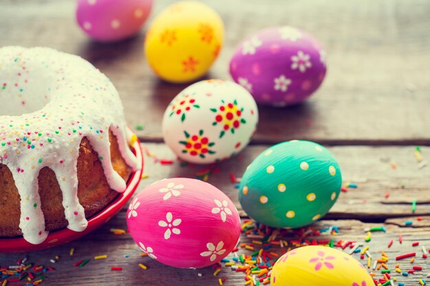 Torta di Pasqua e uova colorate sul tavolo da cucina In stile retrò