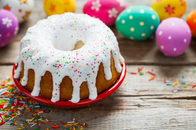 Torta di Pasqua e uova colorate sul vecchio tavolo rustico xAxA