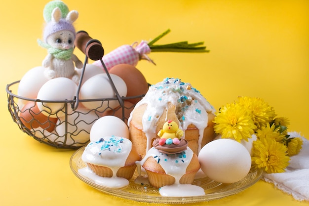 Torta di Pasqua e uova con fiori su sfondo giallo Il concetto della festa di Pasqua