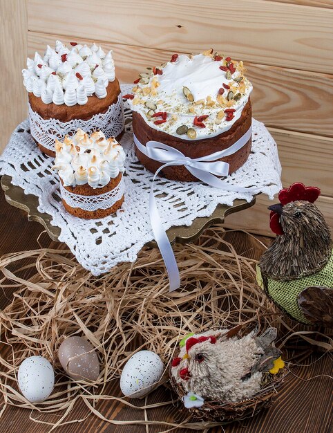 Torta di Pasqua kulich Tradizionale pane dolce pasquale decorato a forma di meringa e zucchero filato uova su piastra su sfondo tavolo in legno