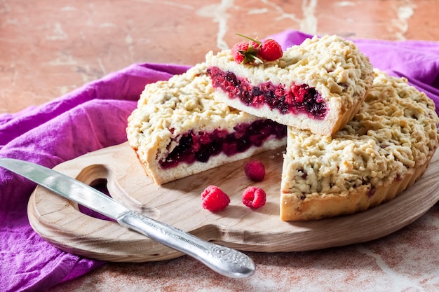 Torta di pasta frolla fatta in casa con frutti di bosco e crumble su tavola di legno