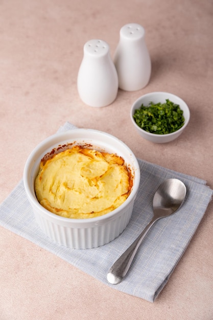 Torta di pastori in un piatto da forno bianco porzionato Gratinato tradizionale casalingo con carne macinata e purè di patate Prossimità di messa a fuoco selettiva