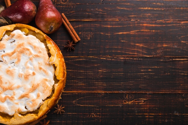 Torta di pere con panna, dolci fatti in casa sul tavolo di legno, con spezie. Copia spazio.