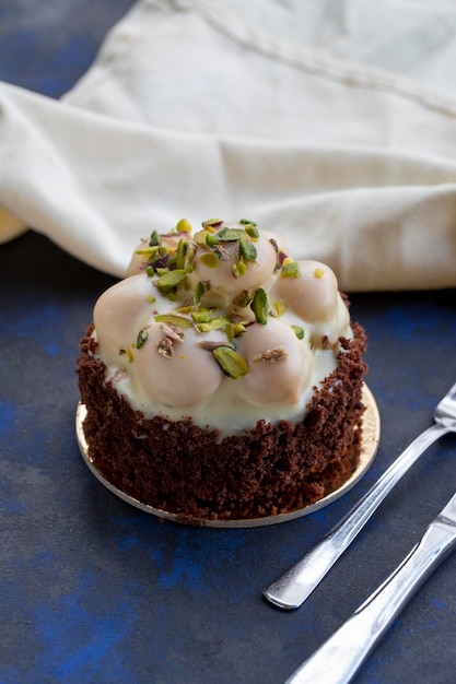 Torta di profiterole al cioccolato bianco su sfondo nero e blu