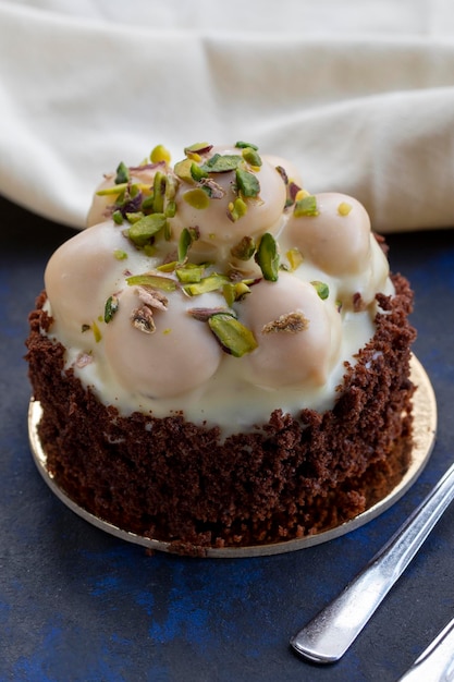 Torta di profiterole al cioccolato bianco su sfondo nero e blu