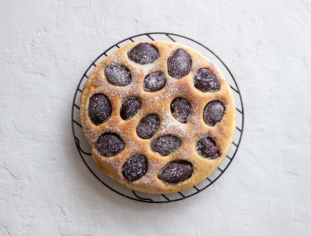 Torta di prugne su uno sfondo bianco. Cottura al forno. Cibo vegetariano.