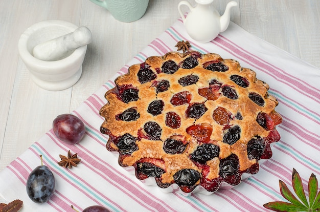 Torta di prugne su uno sfondo in legno chiaro. Cottura fatta in casa