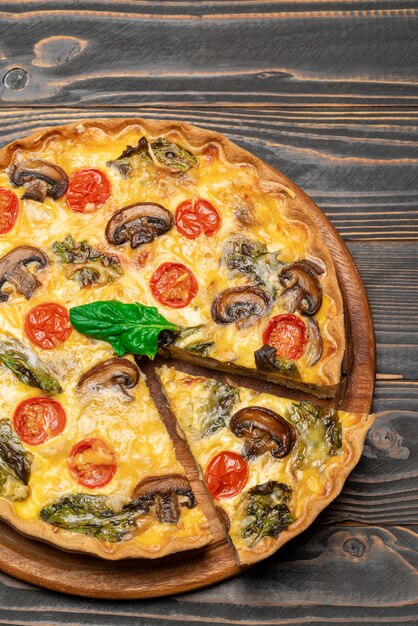 Torta di quiche casalinga al forno francese tradizionale sul bordo di legno