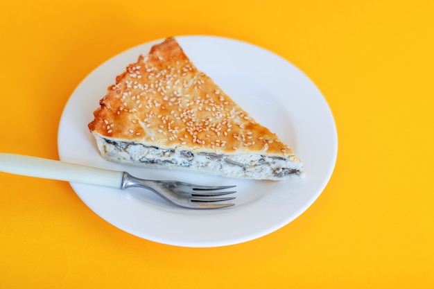 Torta di quiche chiusa di verdure con spinaci e pollo sul piatto bianco