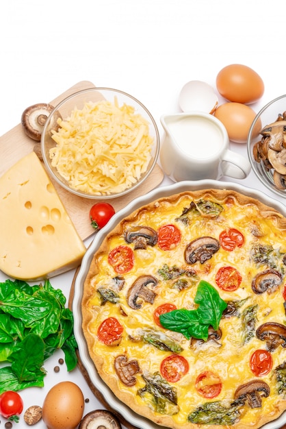 Torta di quiche fatta in casa al forno in forma di cottura in ceramica, uova e panna