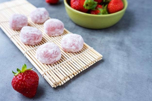 Torta di riso tradizionale giapponese Mochi giapponese con fragola sul tappetino di legno