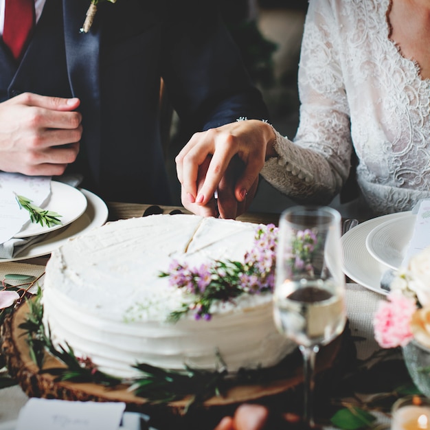 Torta di taglio dello sposo e della sposa su ricevimento nuziale