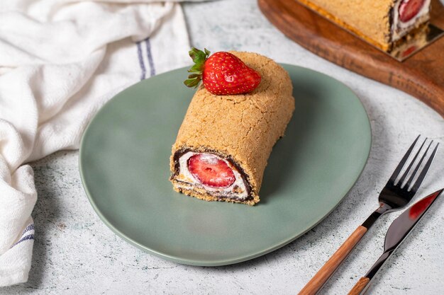 Torta di tronchi arrotolati Torta di fragole e crema su uno sfondo di pietra Dolci di pasticceria