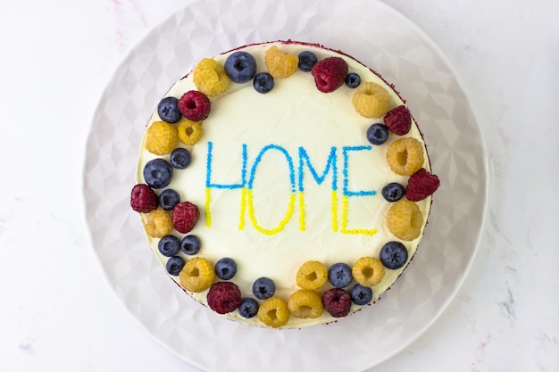 Torta di velluto rosso con un decoro di lamponi e mirtilli gialli e rossi Ritorno a casa