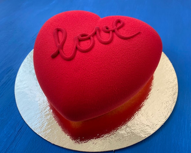 Torta di velluto rosso su un tavolo di legno blu. simbolo dell'amore. Dolce delle feste