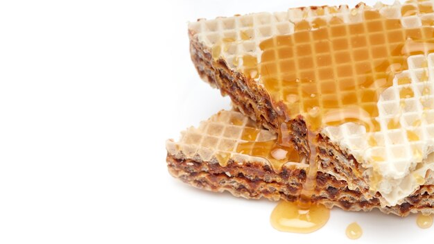 Torta di waffle fatta in casa su un piatto bianco con miele su uno sfondo bianco isolato