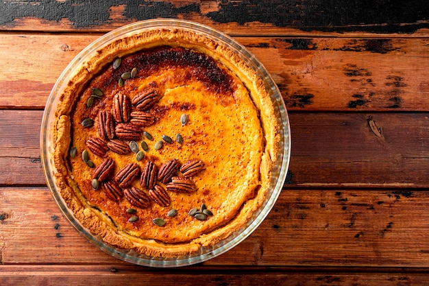 Torta di zucca americana tradizionale con torta di zucca fatta in casa di noci pecan sul vecchio sfondo di legno gratis