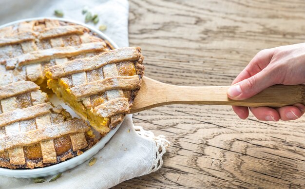 Torta di zucca con mano prendendo una fetta