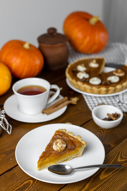 Torta di zucca con una tazza di tè su un tavolo di legno