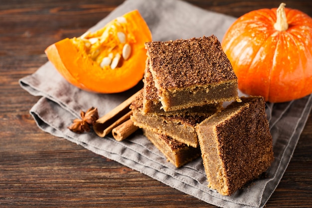 Torta di zucca quadrata o pasticceria con cannella e zucca su sfondo scuro