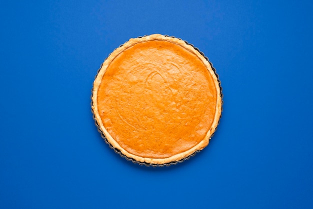 Torta di zucca vista dall'alto minimalista su sfondo blu