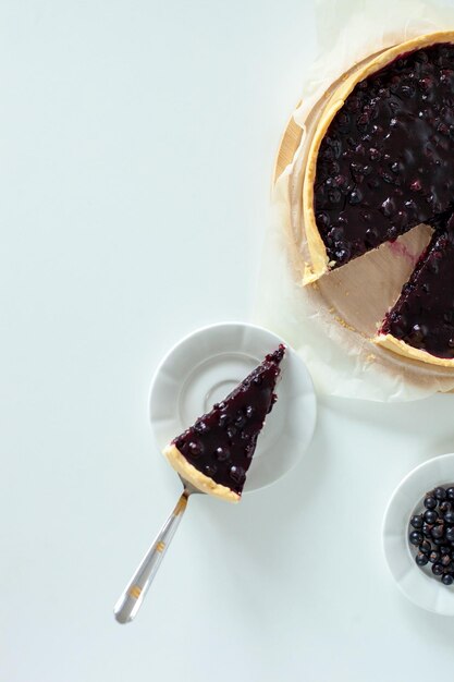 Torta dolce a fette con ribes nero Torta fatta in casa con frutti di bosco estivi su un tavolo bianco Vista dall'alto Gustosi dolci da forno