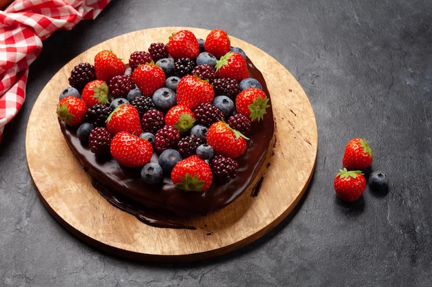 Torta dolce a forma di cuore con frutti di bosco