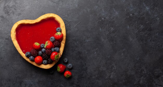 Torta dolce a forma di cuore con frutti di bosco