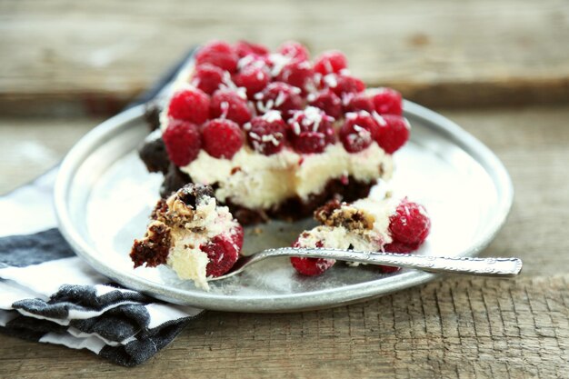 Torta dolce con lamponi sullo sfondo di tavolo in legno