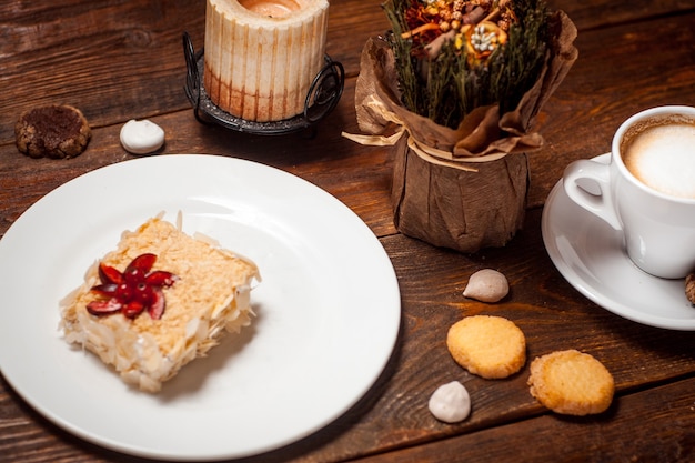 Torta dolce con una tazza di caffè sulla tavola di legno