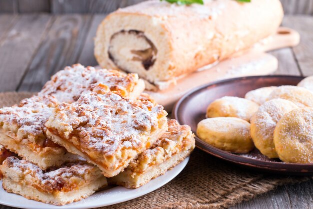 Torta dolce rotolo e cotto su un tavolo di legno