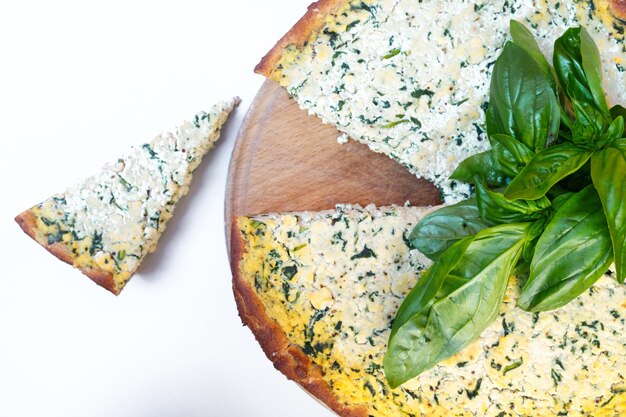 Torta fatta in casa con barbabietola corta con tofu e spinaci decorata con foglie di basilico