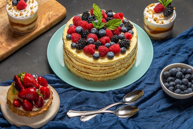 Torta fatta in casa con frutti di bosco freschi e dolci su sfondo scuro.