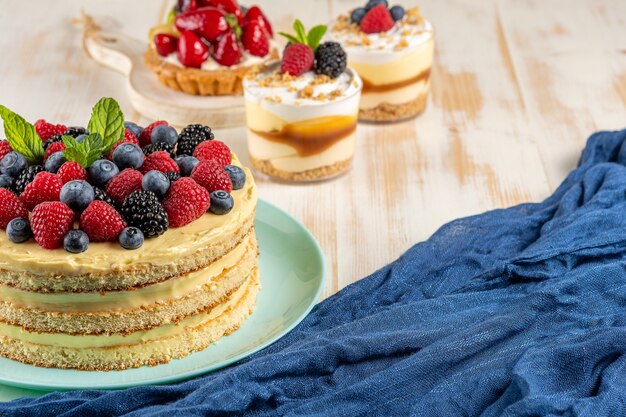 Torta fatta in casa con frutti di bosco freschi su legno