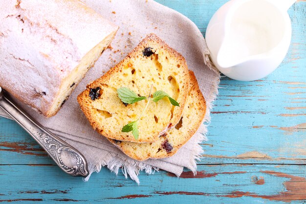 Torta fatta in casa con uvetta e noci tagliati a pezzi su uno sfondo blu