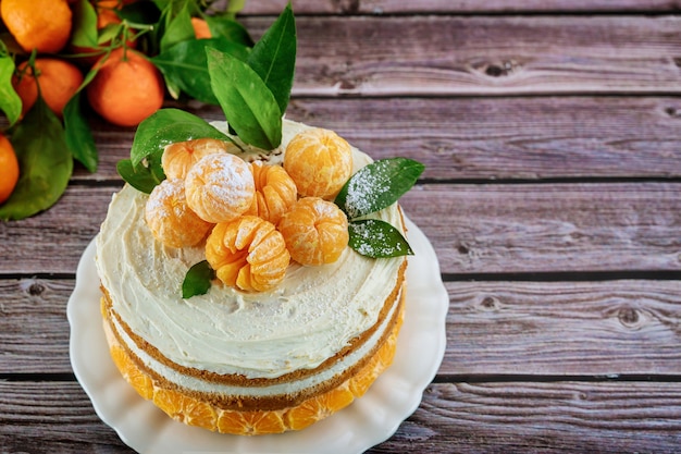 Torta festiva con mandarini interi sulla tavola di legno