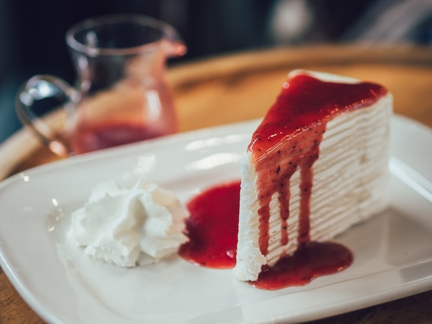 Torta francese di crepe con salsa di fragole succosa nella caffetteria.