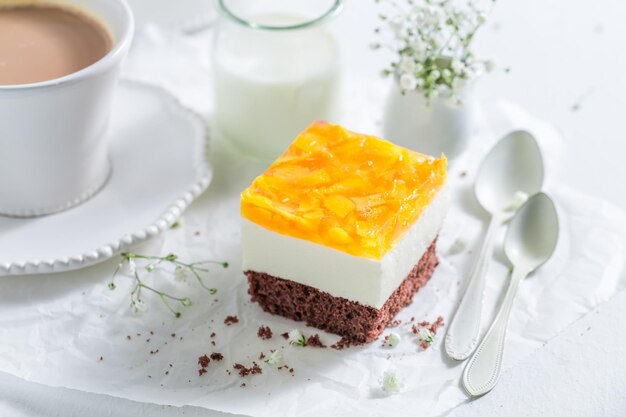 Torta fresca con gelatina e pesche servita con caffè