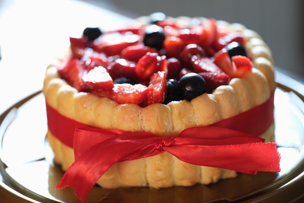 Torta fresca dolce della bacca fresca con il nastro rosso