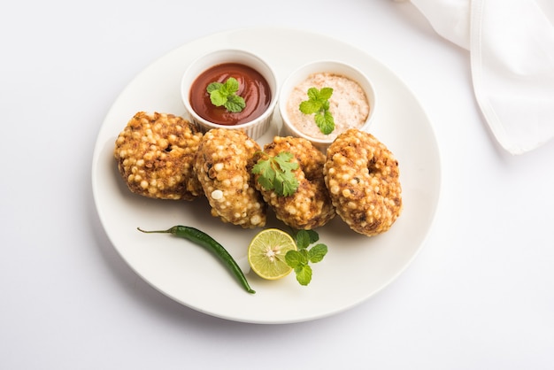 Torta fritta Sabudana vada o Sago servita con chutney di arachidi su sfondo lunatico, ricetta di digiuno popolare dall'India.