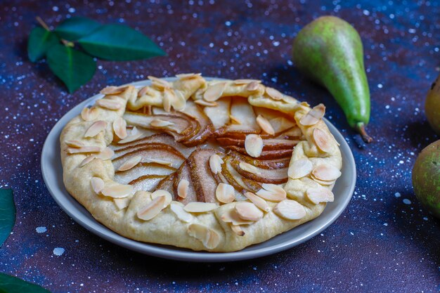 Torta galette di pere fatta in casa con foglie di mandorle e pere verdi mature fresche