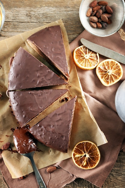 Torta glassata al cioccolato a fette sul tavolo di legno