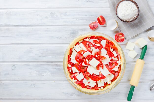 Torta greca grezza con feta e pomodori per cottura