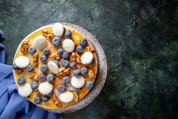 Torta gustosa vista dall'alto con noci mirtilli e biscotti superficie scura