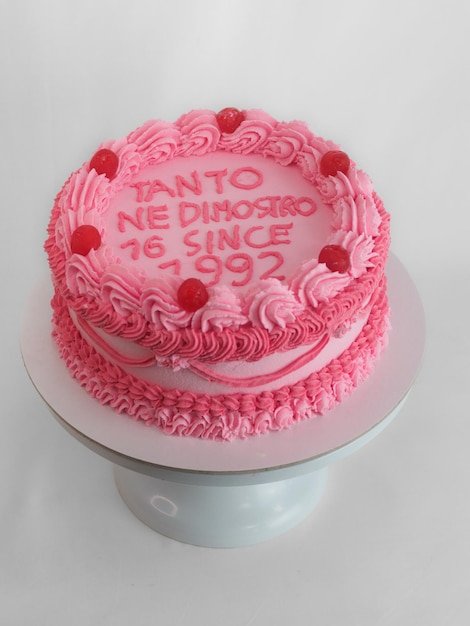 Torta in tazza di glassa rosa con scritta in italiano inglese per il compleanno