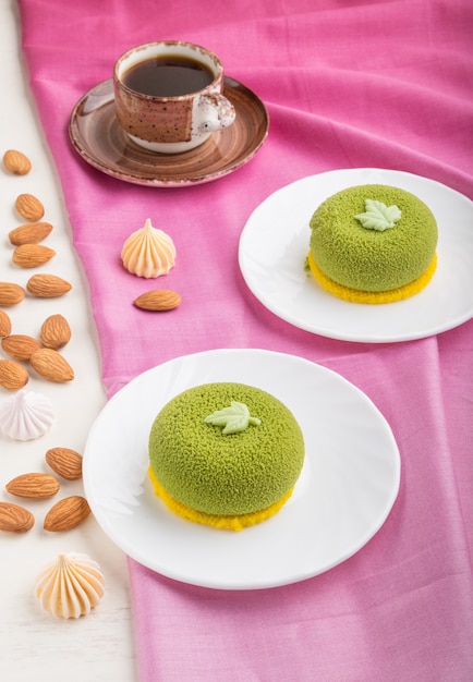 Torta mousse verde con crema al pistacchio e una tazza di caffè. vista laterale