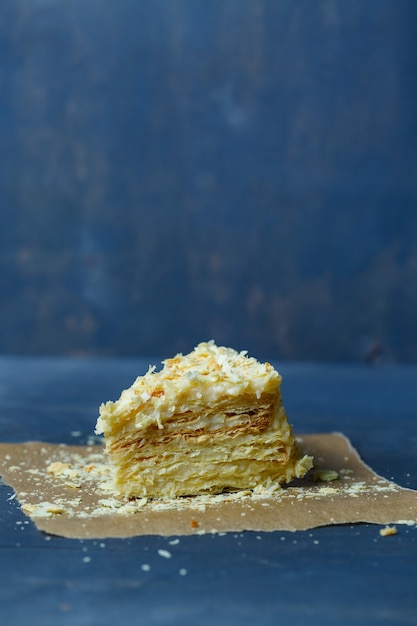 Torta Napoleone fatta in casa con crema su sfondo grigio.