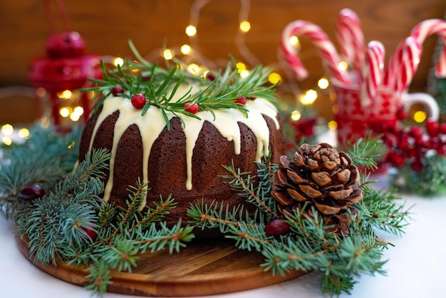 Torta natalizia al caramello, decorata con cioccolato bianco, mirtillo rosso, rosmarino e decorazioni di Capodanno. Prodotti da forno festivi. Messa a fuoco selettiva morbida. Orizzontale