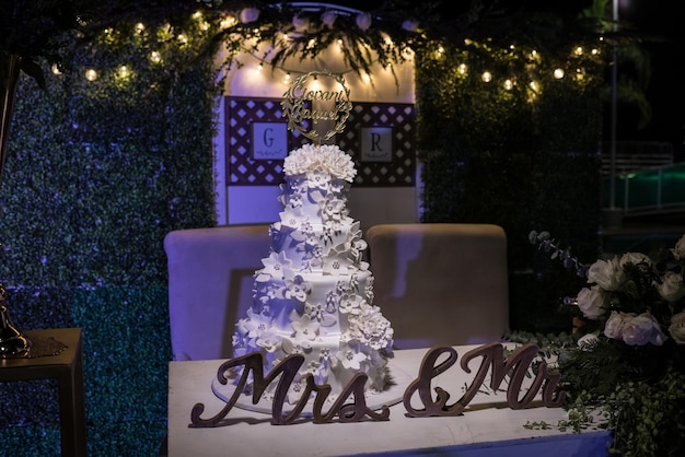 Torta nuziale a quattro piani adornata con tanti fiori di zucchero, esposta al ricevimento